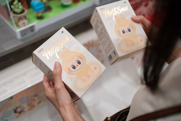 A person holding two boxes of Labubu