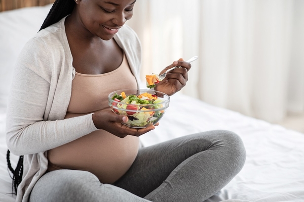 Pregnant woman eating salad