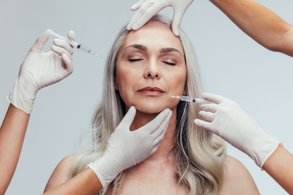 Image woman getting botox injection in face