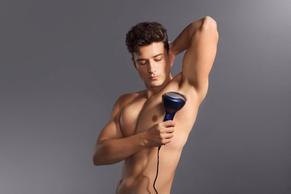 A man using at at-home laser on his armpits.