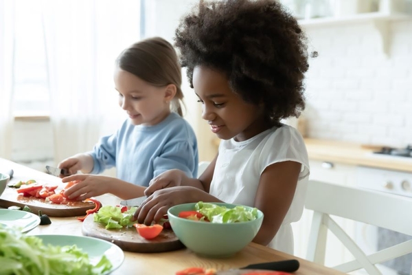 Two children making a salad
