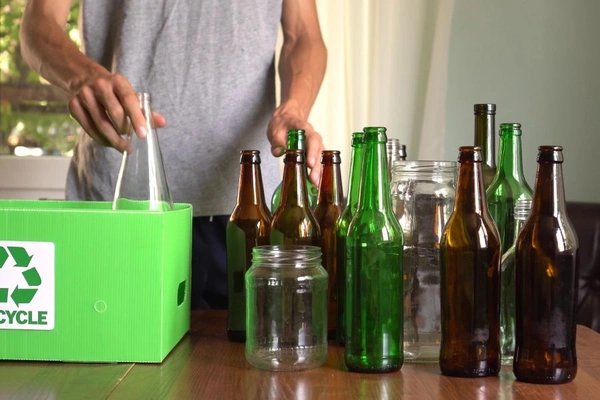 Image man sorting glass bottles into recycled bin