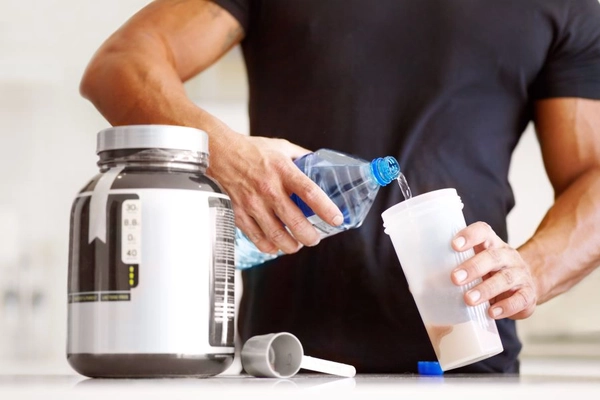 Image a bodybuilder making himself a protein shake