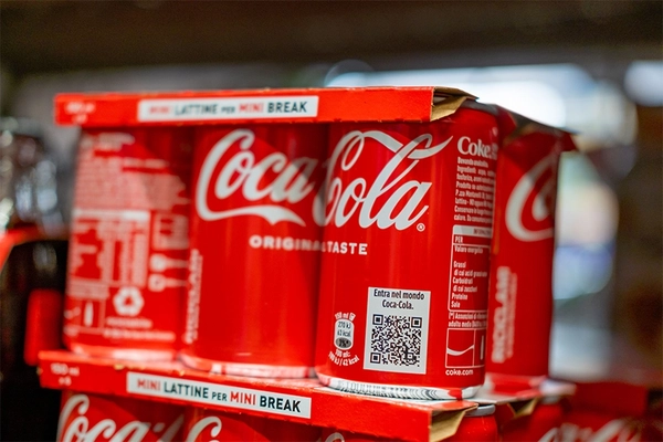 Coca-Cola soda cans on supermarket shelf.
