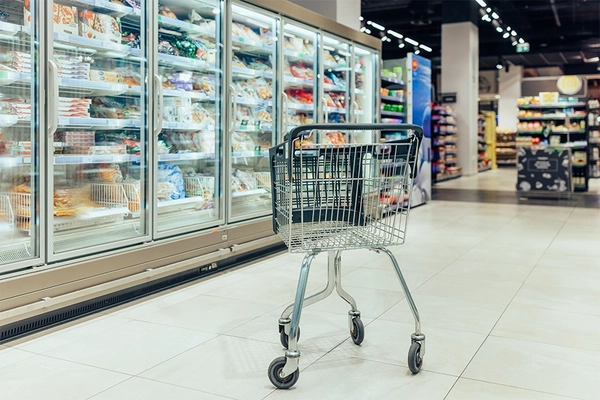 Image Empy shopping cart in the frozen food aisle.