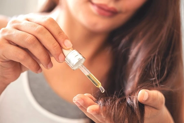 Image Putting oil on hair.