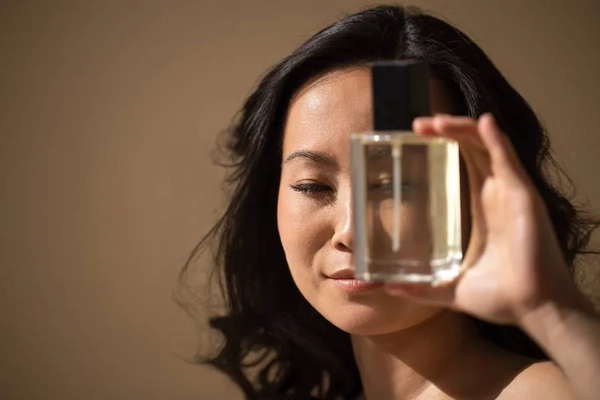 Image Woman holding perfume bottle