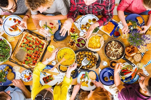 People at a table with lots of colorful foods. People at a table with lots of colorful foods.