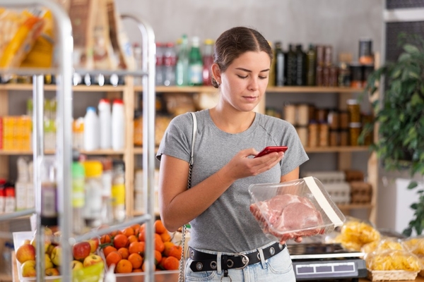 Image Woman shopping for meat in the grocery store.