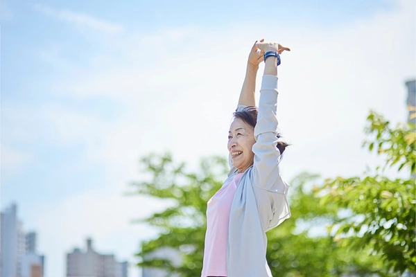 Old asian woman stretching outdoors in park