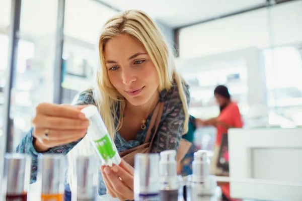 Image A girl inspecting a personal care product.