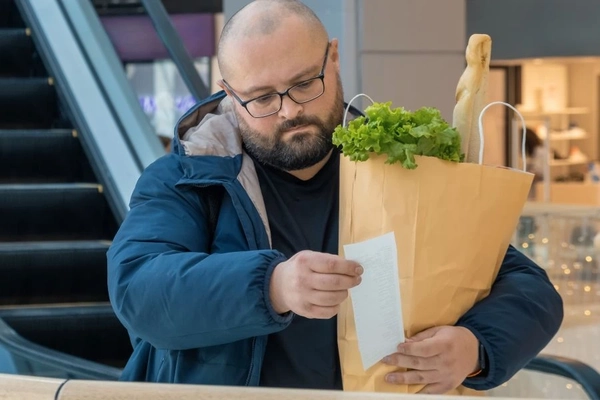 Man checking supermarket receipt