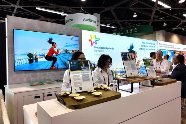 people at trade show booth two women in white shirts at a trade show