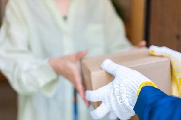 Image A person handing a box to another person