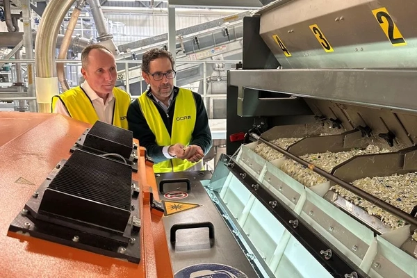 Image Men in yellow vests standing next to a machine