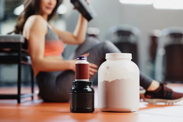 Woman taking sports recovery supplements Woman taking sports recovery supplements