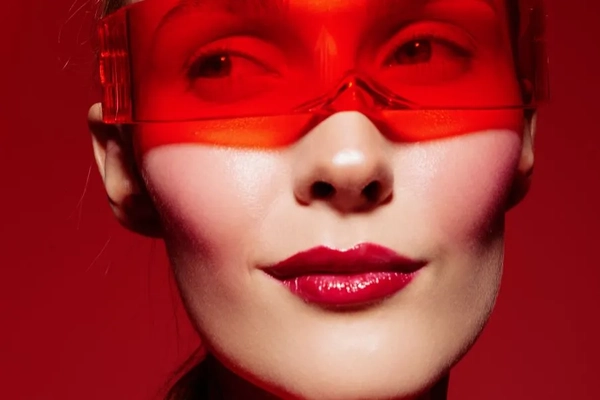 Woman with futuristic red glasses against a red backdrop