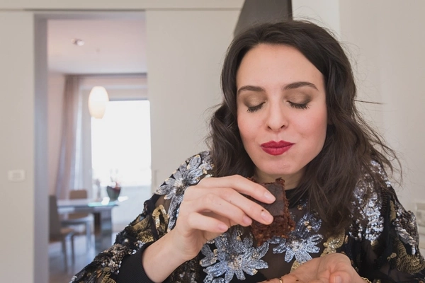woman eating chocolate brownie at home