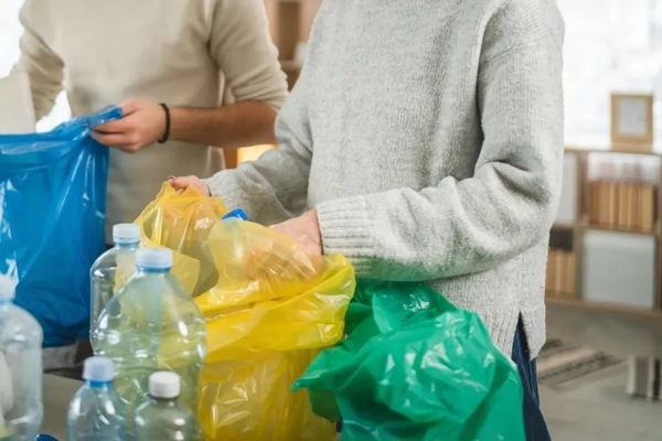 Two people holding bags of garbage