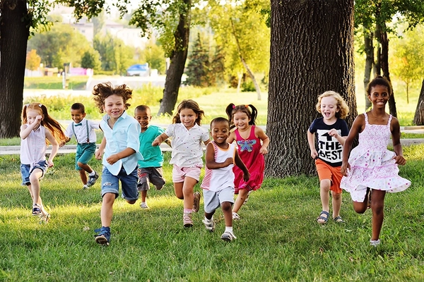 Image A group of happy children of boys and girls run in the Park