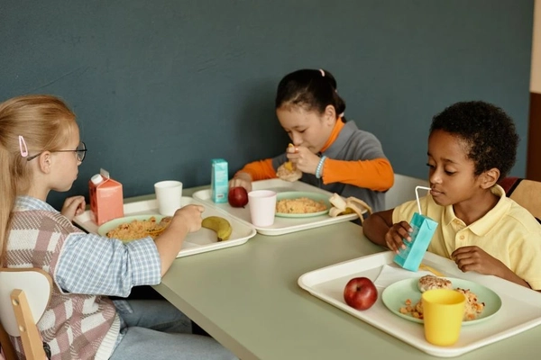 Children drink milk from carton packaging