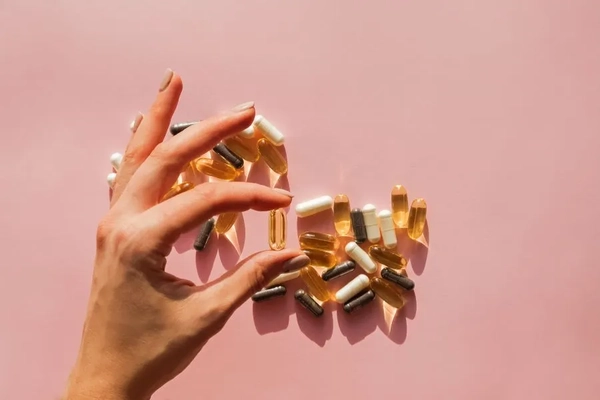 Image woman's hand holding supplements