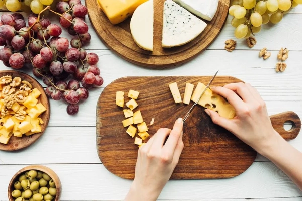 Image person cutting cheeses for platter