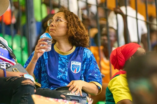 woman drinking water at football game