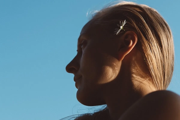 Image A woman with a flower in her hair.