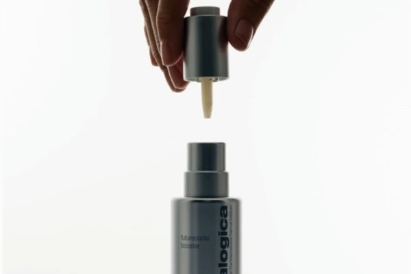 Image A hand holding a bottle of skin care product