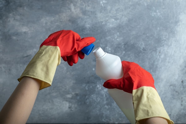 Image someone opening chemical bottle with gloves on