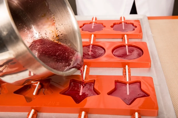 pouring red batter into moulds pouring red batter into moulds