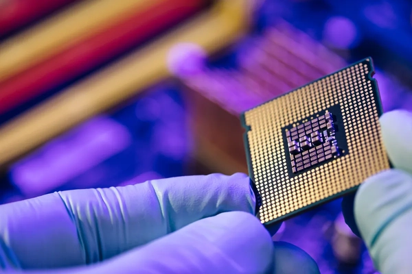 close up of gloved hand holding semiconductor