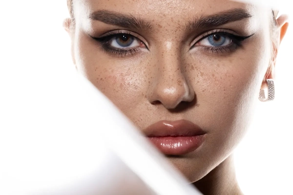 Woman with freckles against white backdrop