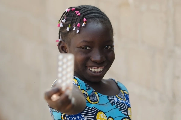 Little girl holding up zinc pills Little girl holding up zinc pills