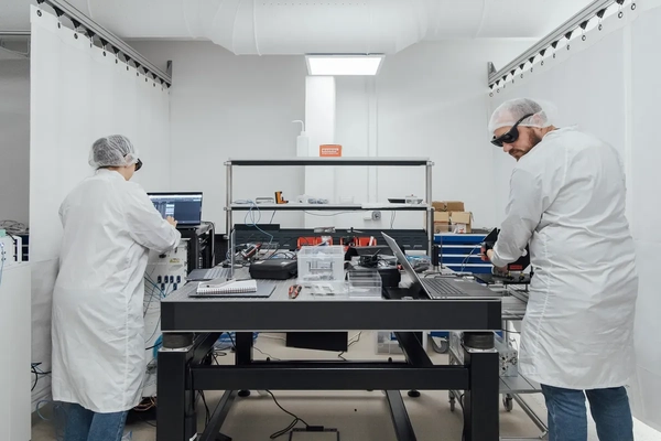 Image Two scientists working with laptops and other technical devices.