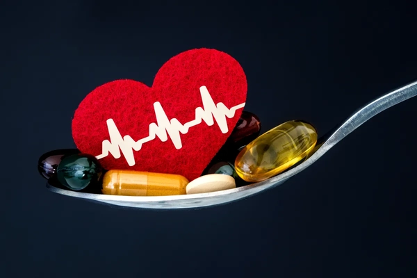 Supplements and a heart shape cut out on a spoon