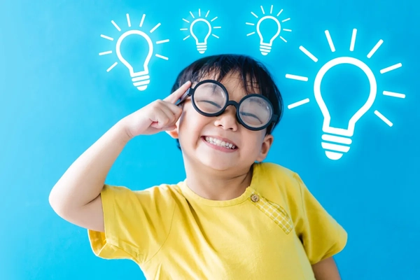 Image boy wearing glasses, smiling points his index finger to his head, with light bulbs above his head