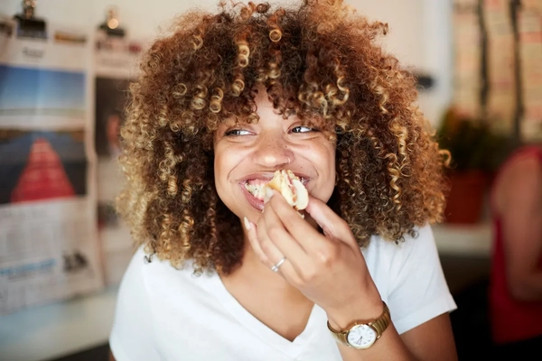 Image Woman eating a sandwich.