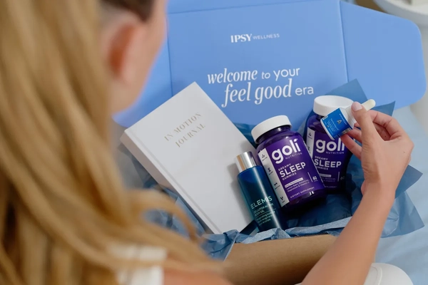 Image A woman opening an Ipsy wellness box.