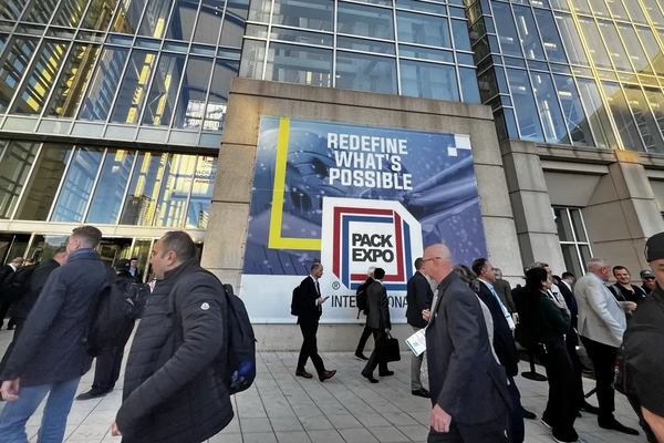 a sign outside of a building with people passing by