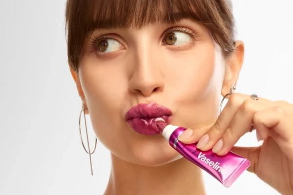 woman applying  vaseline lip gloss 