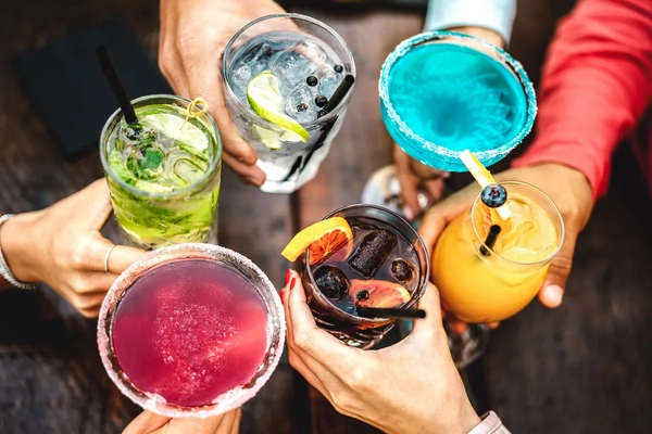 Cheersing with colorful drinks.
