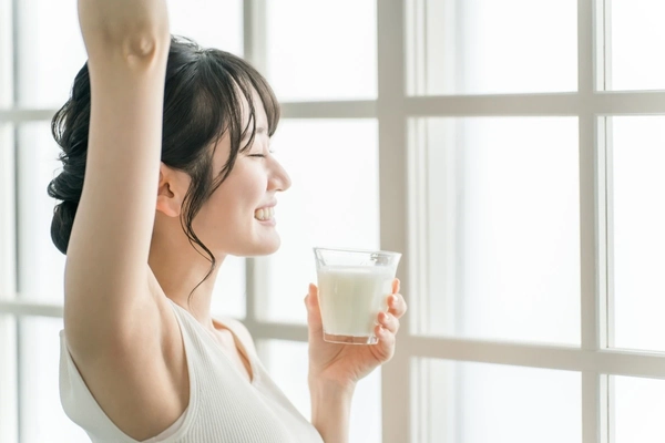 Woman drinking milk in the morning at home.