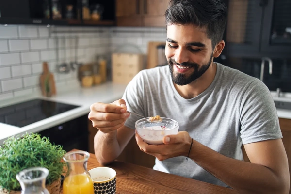 Image fit man in kitchen table eating cereals